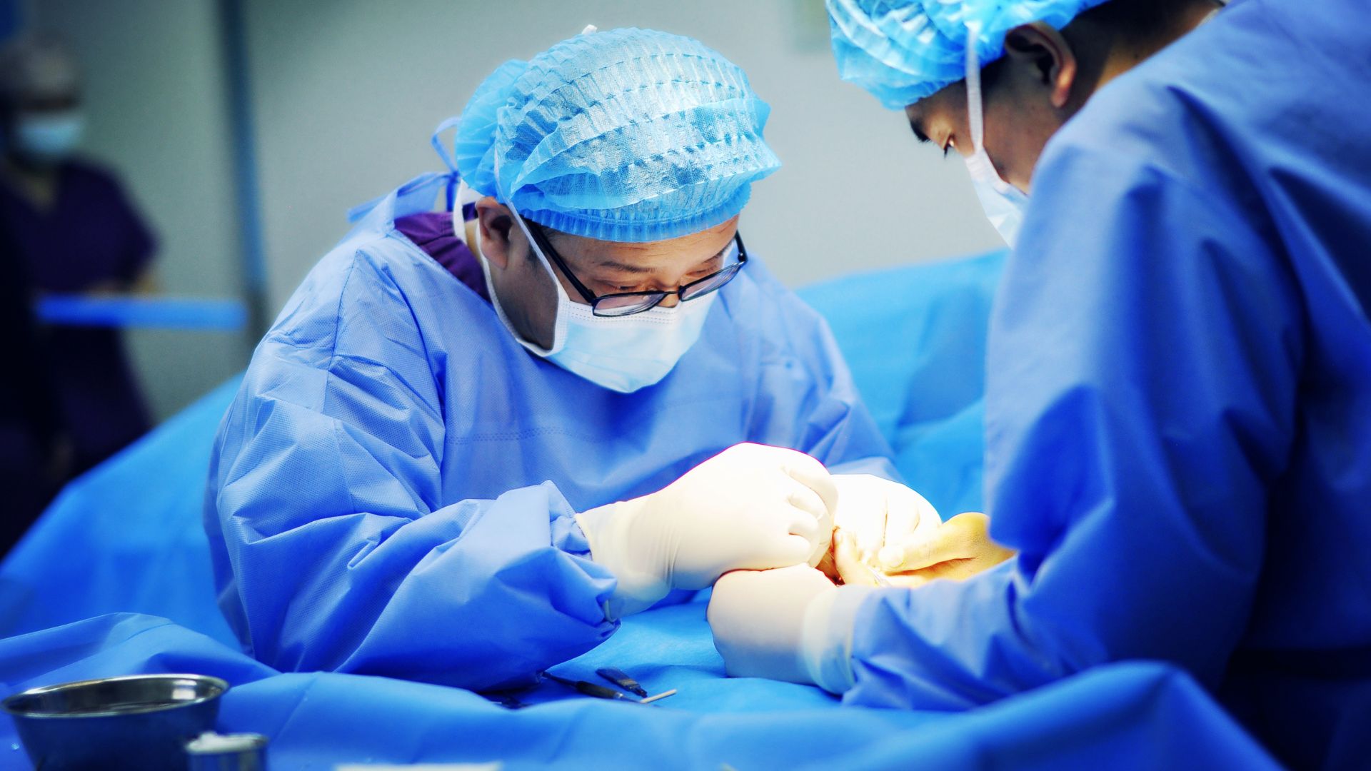Surgeons performing a medical procedure using precision surgical instruments manufactured to tight tolerances.