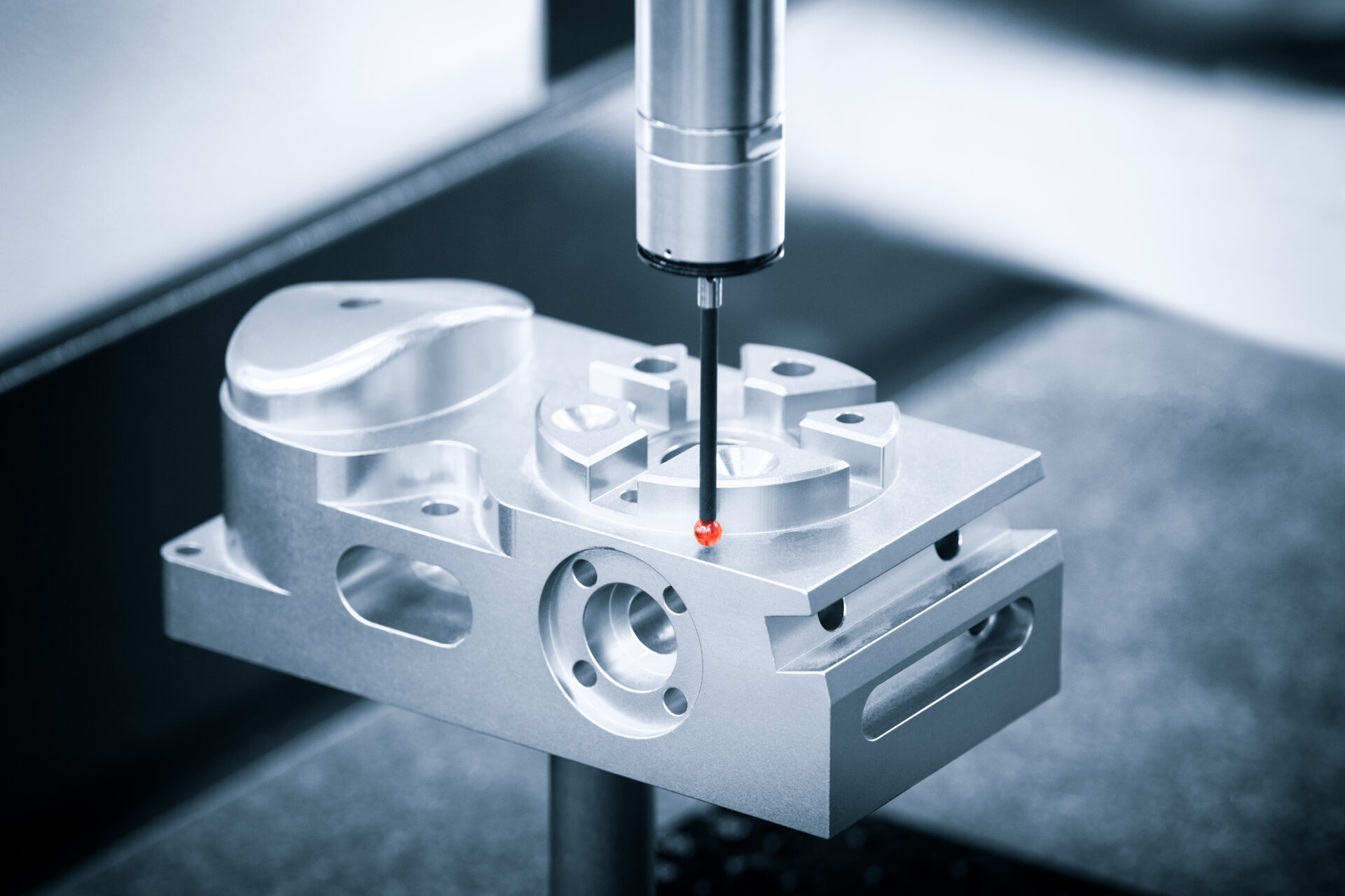 Coordinate measuring machine (CMM) inspecting a precision CNC machined component for dimensional accuracy.